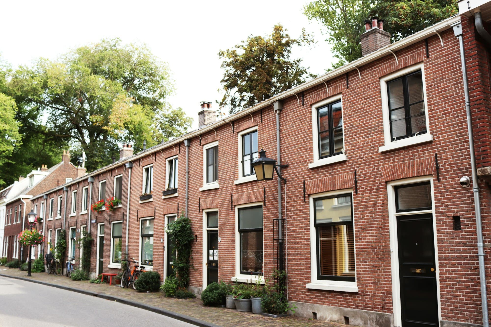 Nederlandse straat met bakstenen rijtjeshuizen en pannendaken in natuurlijk licht